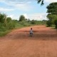 child riding bike on red dirt road