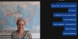 Nina Buschmann unterrichtet online mit Weltkarte im Hintergrund und Unterrichtschatfenster offen
